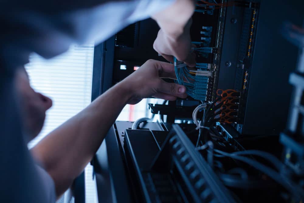 Hard working experienced technician working with network cables